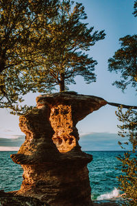 Rock formation on beach against sky