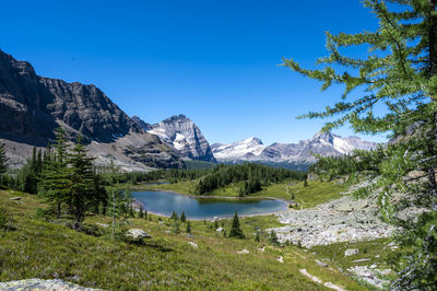 Scenic view of lake and mountains against blue sky