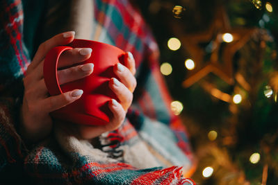 Midsection of woman with illuminated christmas lights