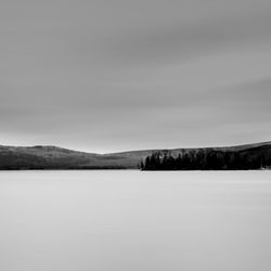 Scenic view of lake against sky during winter