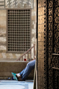 Low section of man working on window of building