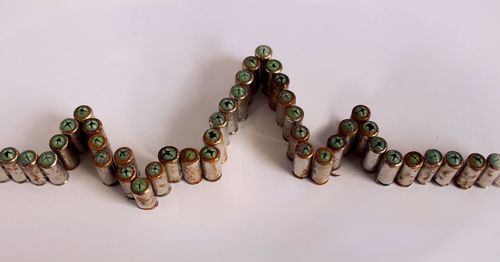 High angle view of bullets arranged in pulse trace at table