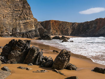 Rocks on beach against sky