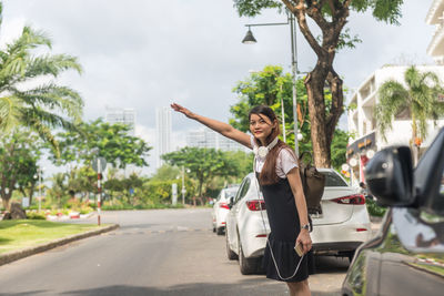 Woman with umbrella on road in city