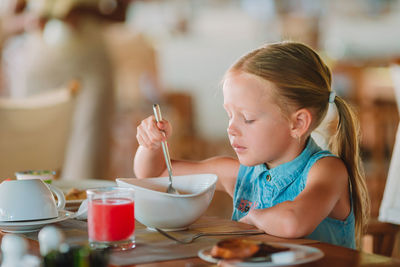 Close-up of girl eating food at home