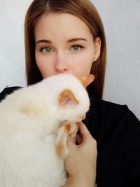 Close-up portrait of beautiful young woman with cat