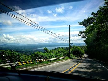 Scenic view of road by mountains against sky