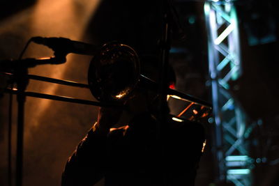 Silhouette person playing trumpet at music concert