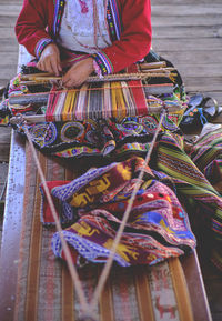 Indigenous woman showing traditional weaving technique and textile making in the andes mountain