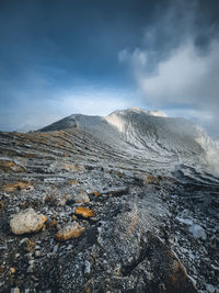 Smoke emitting from volcanic mountain against sky