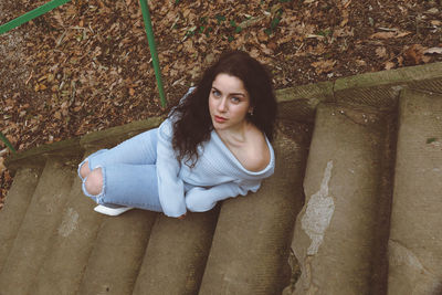 Portrait of beautiful young woman sitting outdoors
