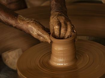 Cropped hands making pot