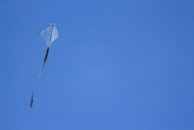 Low angle view of helicopter flying against clear blue sky