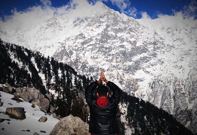 Rear view of person standing on snow covered mountain