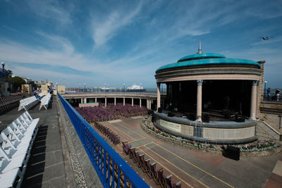 Train at railroad station in city against sky