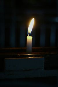 Close-up of lit candles in darkroom