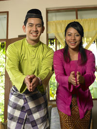 Portrait of smiling couple gesturing at home