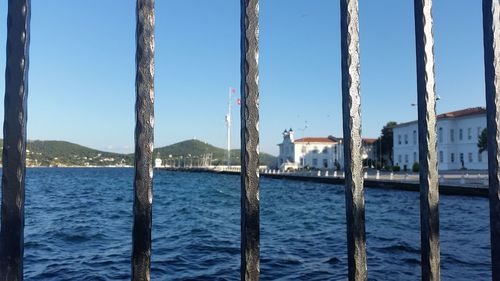 Scenic view of sea and buildings against clear sky