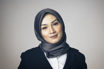 Portrait of smiling young woman against white background