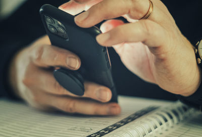 Midsection of man using mobile phone