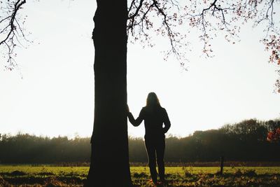 Silhouette woman on field against clear sky