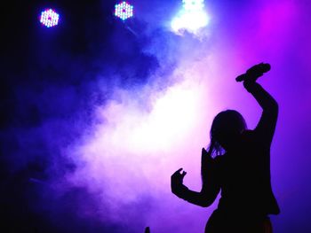 Silhouette woman performing at musical concert