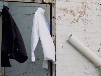 Close-up of clothes drying against white wall