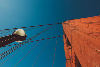 Low angle view of telephone pole against clear blue sky