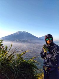 Man standing on mountain against clear blue sky