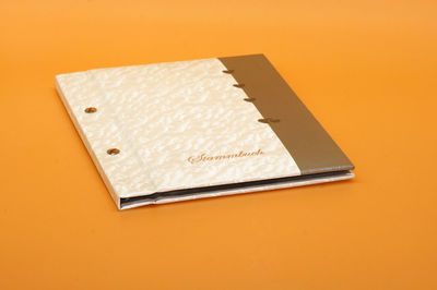 High angle view of paper against orange background