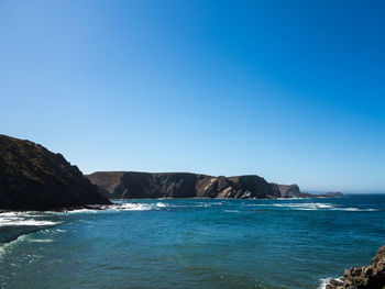 Scenic view of sea against clear blue sky