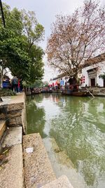 Scenic view of river in city against sky