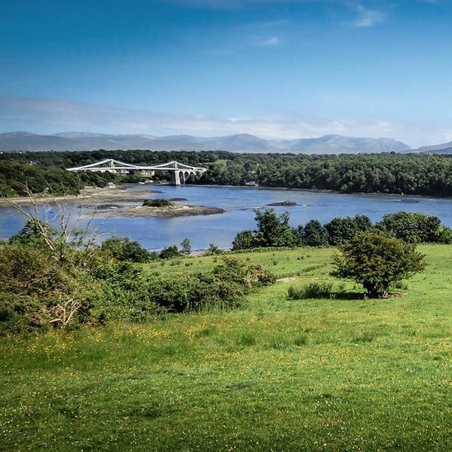 water, tranquil scene, tranquility, sky, lake, mountain, grass, scenics, beauty in nature, nature, tree, river, blue, plant, growth, green color, landscape, idyllic, mountain range, day