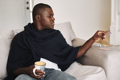 Young man sitting on sofa at home