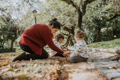 Mother playing outdoors with two children