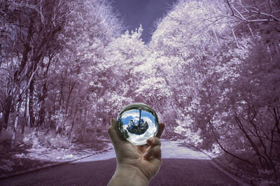 Digital composite image of hand holding glass