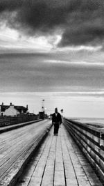 Full length of woman on landscape against cloudy sky