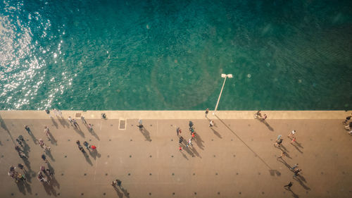 High angle view of people walking on promenade by sea