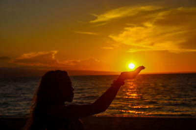 Silhouette woman at beach during sunset