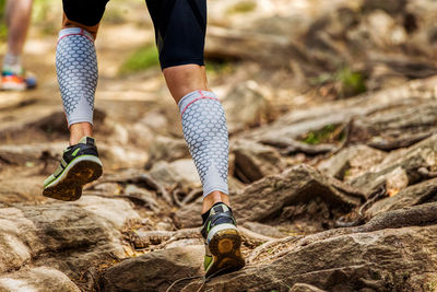 Low section of person running on rocks