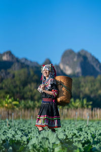 Woman standing on mountain against clear blue sky