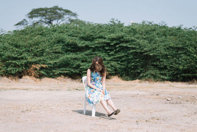 Girl sitting on chair at beach