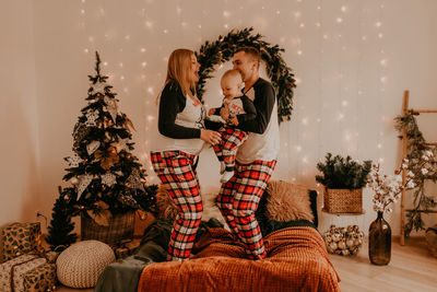 Portrait of smiling young woman holding christmas tree