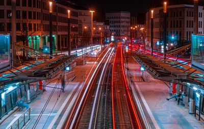 High angle view of light trails on street amidst buildings at night