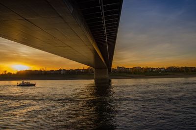 Bridge over river against sky during sunset