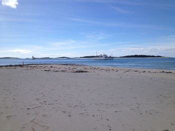 Scenic view of beach against blue sky