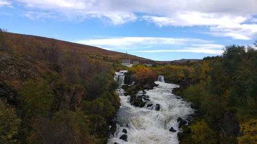 Scenic view of waterfall against sky