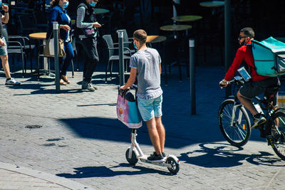 Men with bicycle on street in city