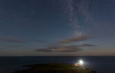 Scenic view of sea against star field at night