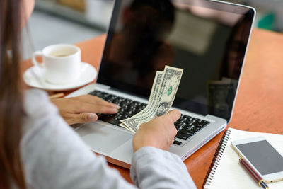 Midsection of man using laptop on table